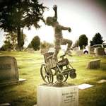 image for A grieving Dad designed this tombstone of his paralyzed-from-birth son climbing out of his wheelchair and reaching for the sky