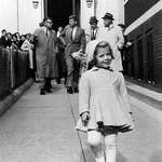 image for Caroline Kennedy walks ahead while her father carries her doll (1960)