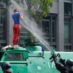 image for Girl on Police Tank in Hamburg Protests. Yes, it is pepper spray.
