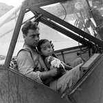 image for An American soldier cradles a wounded Japanese boy and shelters him from the rain in the cockpit of an airplane during the Battle of Saipan while waiting to transport the youngster to a field hospital. July, 1944. [OS][1500 × 1269]