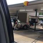 image for An elderly man sitting outside of his car door spoon feeding his wife ice cream
