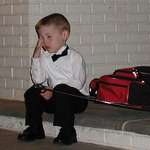 image for My little cousin after an all-day wedding affair (the suitcase contains his travel toys)