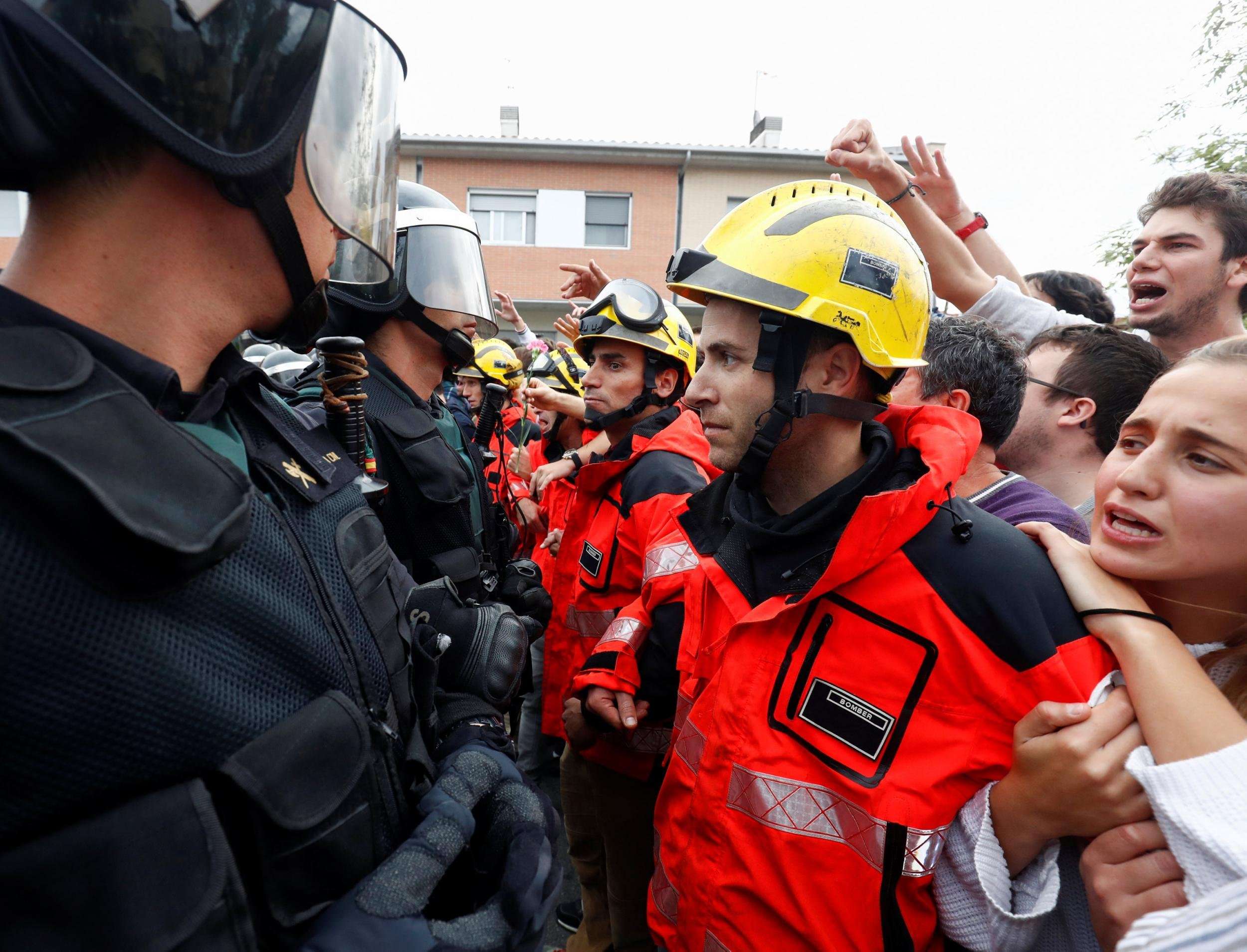image for Catalonia firefighters form human shield to protect referendum voters from riot police