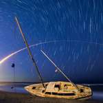 image for I created a long-exposure composite of last week's Atlas V launch and star trails above an abandoned sailboat.