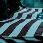 image for In the Watchmen, The Comedian's funeral has the flag draped over his coffin for service in Vietnam. Notice there are 51 stars on the flag, because in Watchmen's 1985, Vietnam is a state, thanks to Dr. Manhattan and The Comedian's involvement.