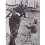 image for East German soldier helping a boy cross the new Berlin Wall, to reunite with his family. 1961.