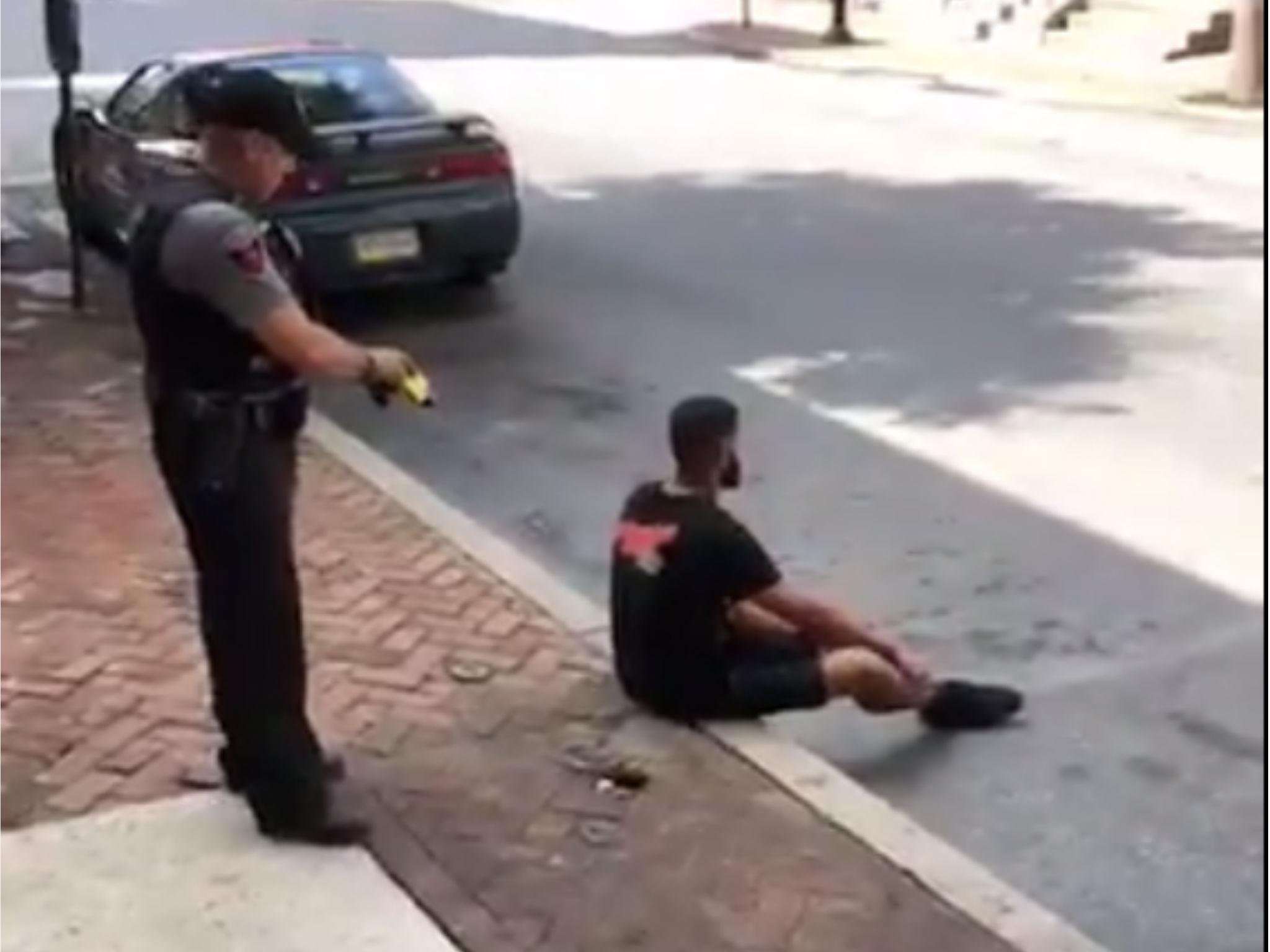 image for Unarmed black man tased by police in the back while sitting on a curb