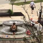 image for Family brought their kids in swimsuits with pool toys to the mall fountain