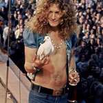 image for Robert Plant of Led Zeppelin holding a dove that flew into his hand during a concert in 1973.