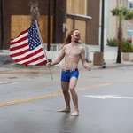 image for PsBattle: Red-Headed Man Wearing Blue Underwear Standing in Street with American Flag During Hurricane Florence