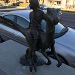 image for My town has a sculpture of a child riding a velociraptor