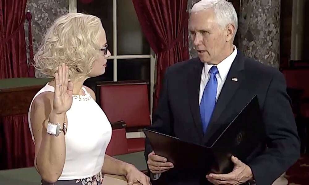 image for First openly bisexual senator forgoes the bible and has Mike Pence swear her in on a law book