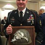 image for Solider receives his mounted helmet that took a 7.62 round at 20' while wearing it.