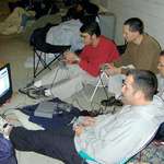 image for A group of guys outside Best Buy playing PS1 while waiting in line for the greatly anticipated Playstation 2. (2000)