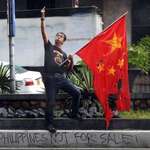 image for Filipino giving the finger to the Chinese embassy while burning their flag.