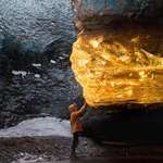 image for Travel photographer Sarah Bethea captured this breathtaking photo last winter in Iceland of a setting sun’s golden rays entering an ice cave and turning a section of the cave’s ice amber.