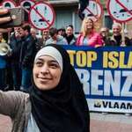 image for Young Muslim woman takes a selfie in front of an anti-Muslim protest