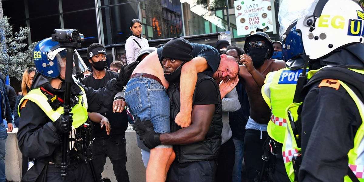 image for This powerful image of a Black man carrying a white counter-protester to safety frames a day of chaos and race-inspired violence in London
