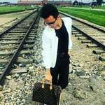 image for Dude is flexing his Louis Vuitton bag on Auschwitz train tracks.