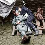 image for A Serbian soldier sleeps with his father who came to visit him on the front line near Belgrade, circa 1914-1915.