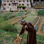 image for Monk in Italy taking a break to pet a kitty.