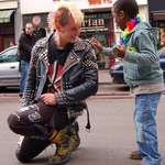 image for A punk guy stopping to let a kid touch the spikes of his jacket during the gaypride.