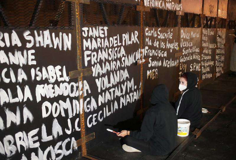 image for Activists paint barriers with names of female victims of violence in Mexico