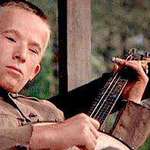 image for In Deliverance (1972), during the “dueling banjos” scene, Billy Redden, who played the young banjo-playing local, didn’t know how to play banjo. To make it look authentic, a skilled banjo player hid behind & played the chords with his left arm in Redden’s sleeve while Redden picked with his right.