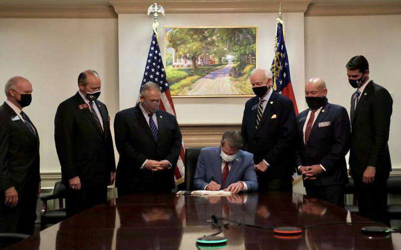 image for Georgia governor reportedly signs voting restrictions into law under portrait of slave plantation