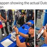 image for A fan asks the Dutch F1 driver Max Verstappen to sign a Russian flag.