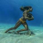 image for Hawaiian Surfer training for large waves by carrying a 50lb stone underwater.