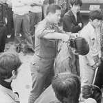 image for A South Korean soldier forcibly cuts a young man's hair in front of others during a nationwide crackdown on men with long hair and women wearing short skirts in South Korea - 1970s [740x355]