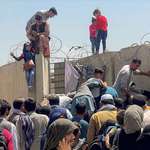 image for Afghanis trying to get their children over the wall outside Kabul airport, in hope of evacuation