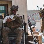 image for A Marine at Kabul Airport comforts a crying infant waiting for evacuation