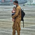 image for An Afghan refugee with his infant arrives in India on an IAF C-17 amidst rainfall at Hindon Base