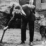 image for Martin Luther King Jr. removing a burned cross from his yard with his son in 1960