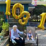 image for My son celebrating his first birth day with his 103 year old grandma. Both born on the same day.