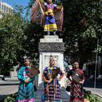 image for Indigenous women in traditional regalia stand over a former monument to Columbus in Detroit
