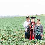 image for College grad with her immigrant parents in fruit fields where they worked to give her a better life.