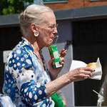 image for Queen of Denmark casually enjoying her juice box, hot dog and cigarette.