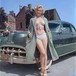 image for Marilyn Monroe poses for a portrait next to a 1950 Pontiac Chieftain in 1951.