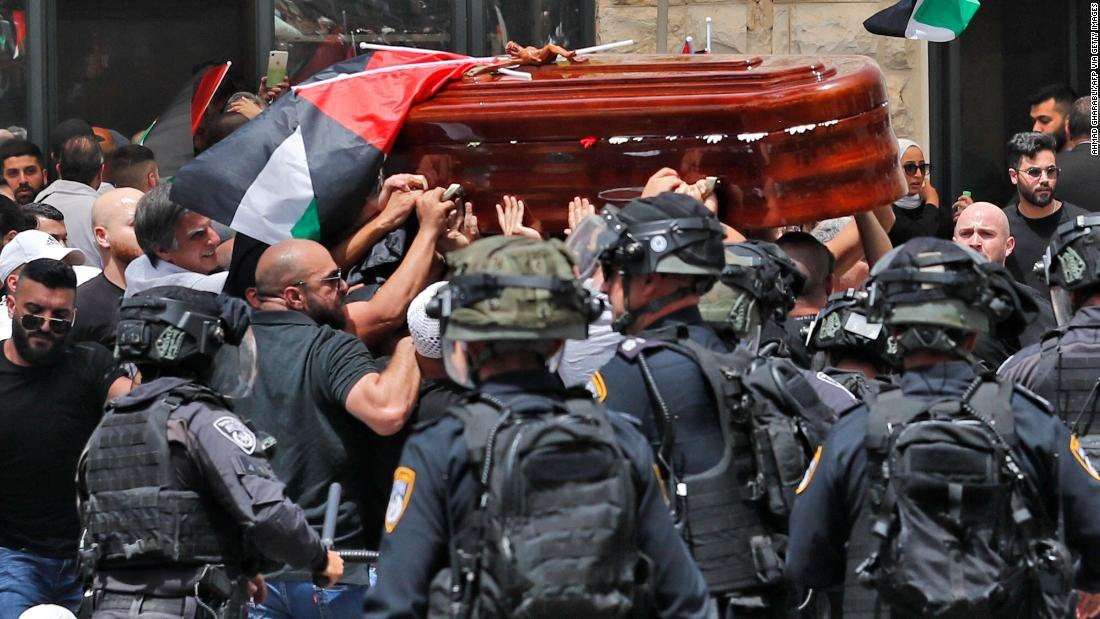 image for Coffin carrying veteran journalist's body shown falling as Israeli police beat mourners with batons