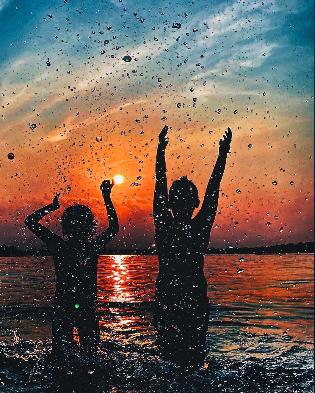 image showing ITAP of my friend’s kids playing in a lake at sunset.