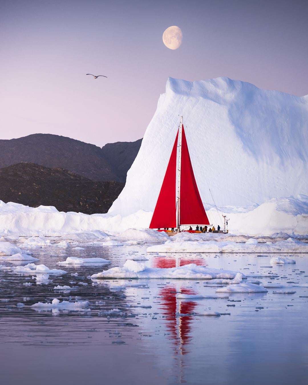 image showing ITAP of a red sailboat with icebergs