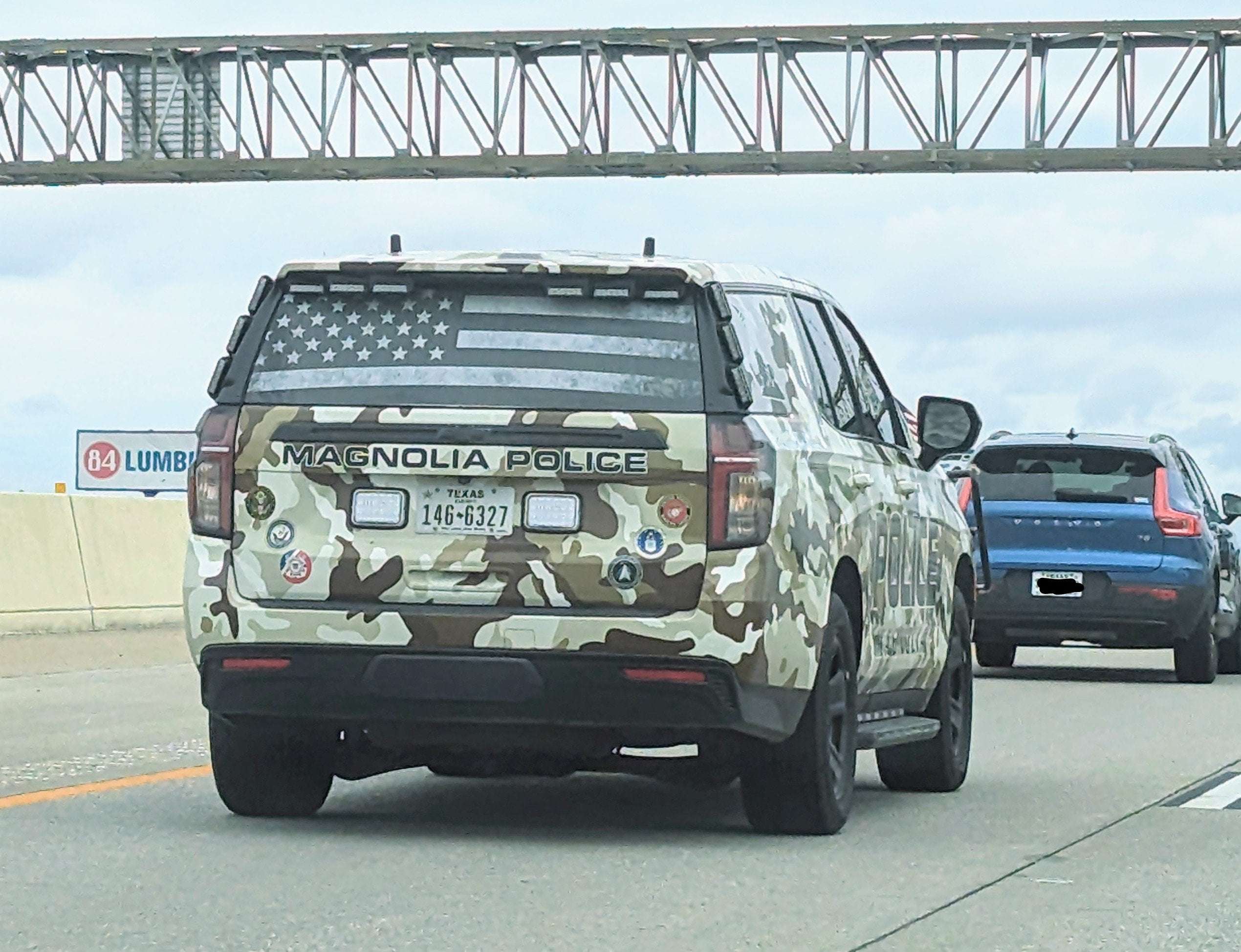 image showing A forest camo Texas police car with military symbols