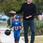 image for Chris walking with his son wearing a Captain America costume.