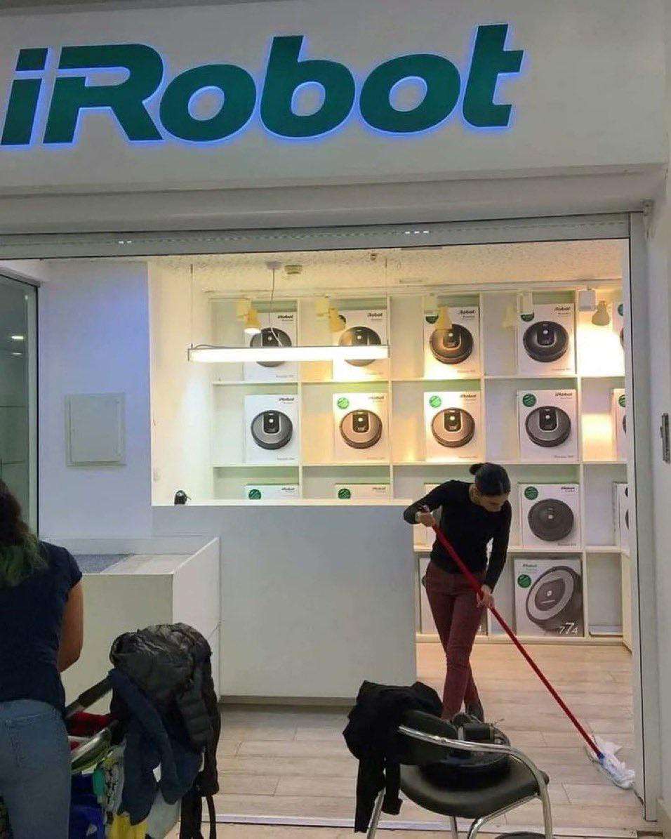 image showing An employee cleaning the floor of a Roomba store