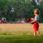 image for ITAP of our son with his tractor while our neighbor plowed with the real thing