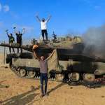 image for Palestinians with a destroyed Israeli tank, October 7, 2023