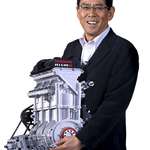 image for The President of Nissan holding a newly designed engine to show off its exceptionally low weight.